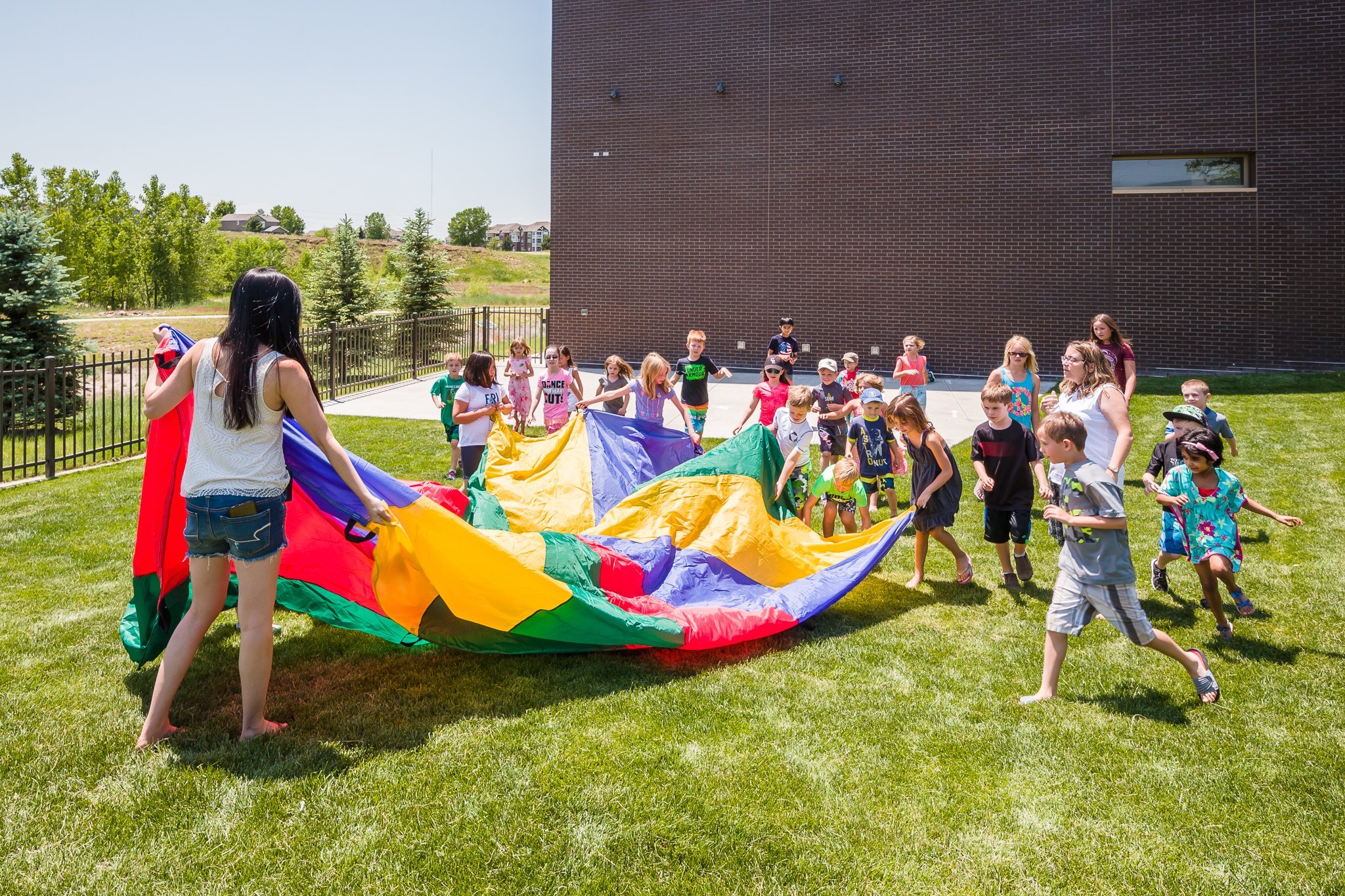 Kids playing with parachute outside of the PACE Center in Parker, CO.