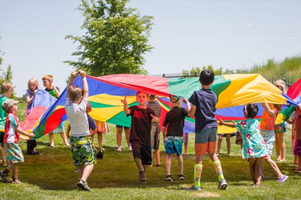Kids playing with parachute outside of the PACE Center in Parker, CO.