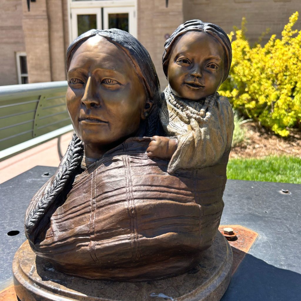 Bronze sculpture of a Sioux mother carrying her young child on her back