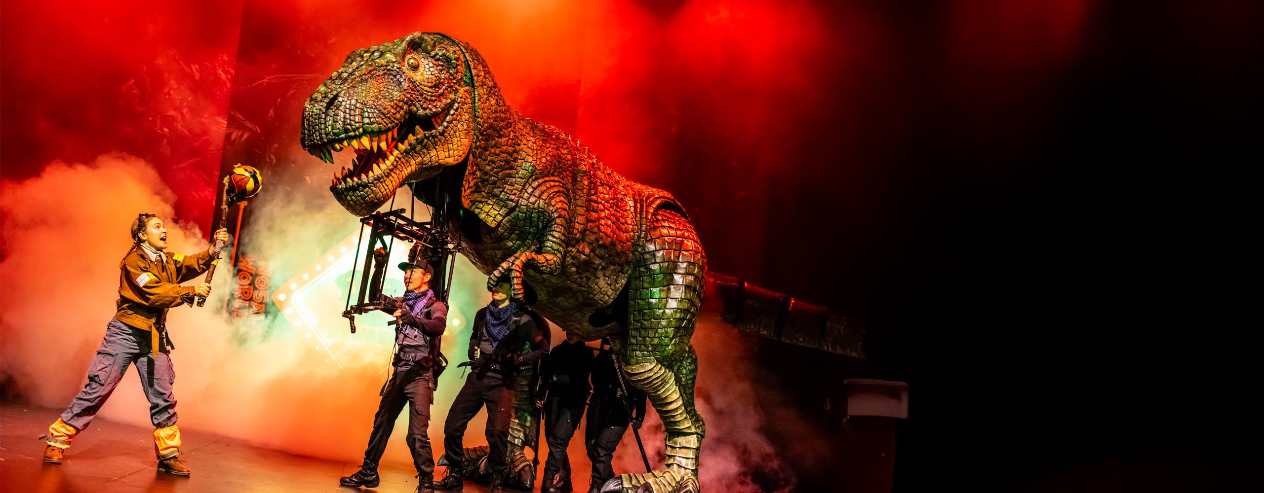A giant T-Rex puppet live on stage.