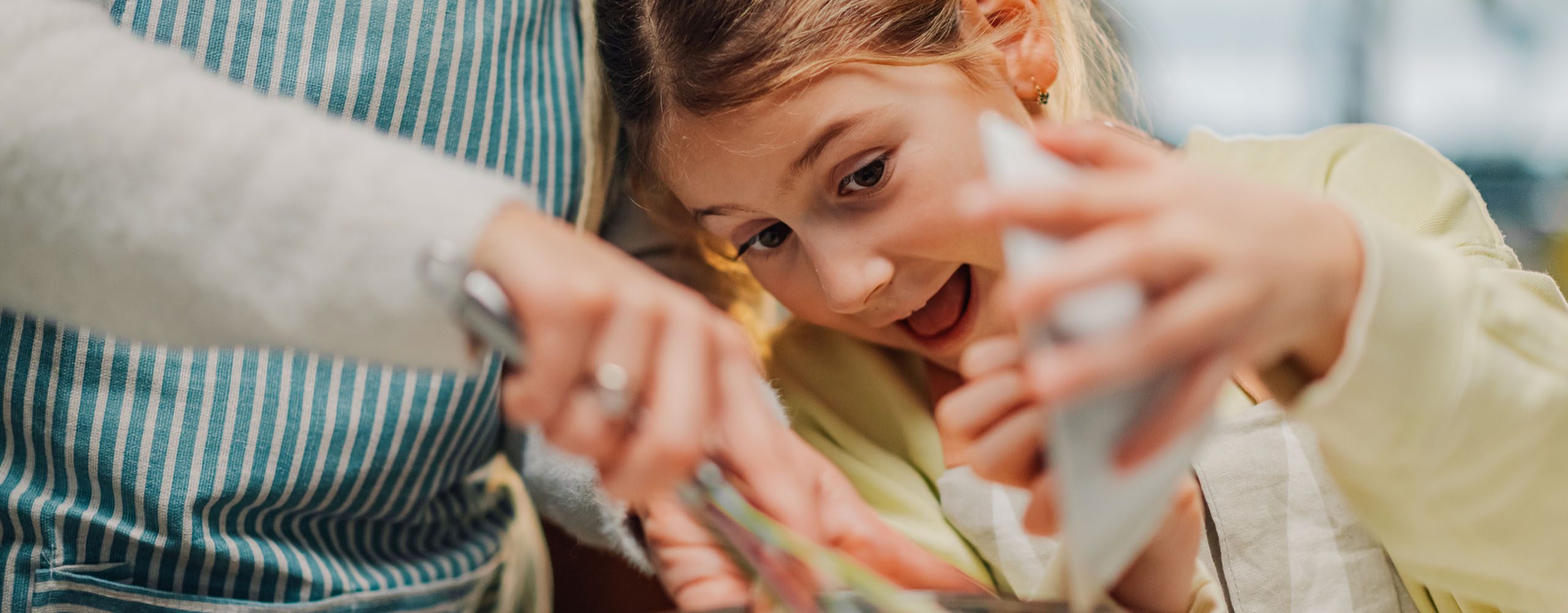 Young girl dumping kitchen ingredients into mixing bowl excitedly
