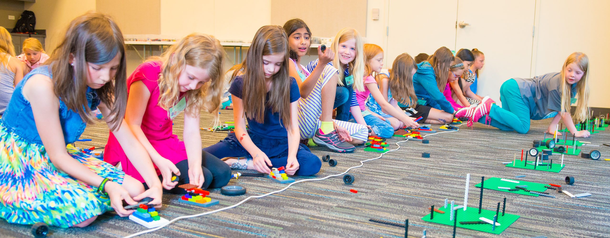 Group of kids on floor in summer camp classroom working on science project