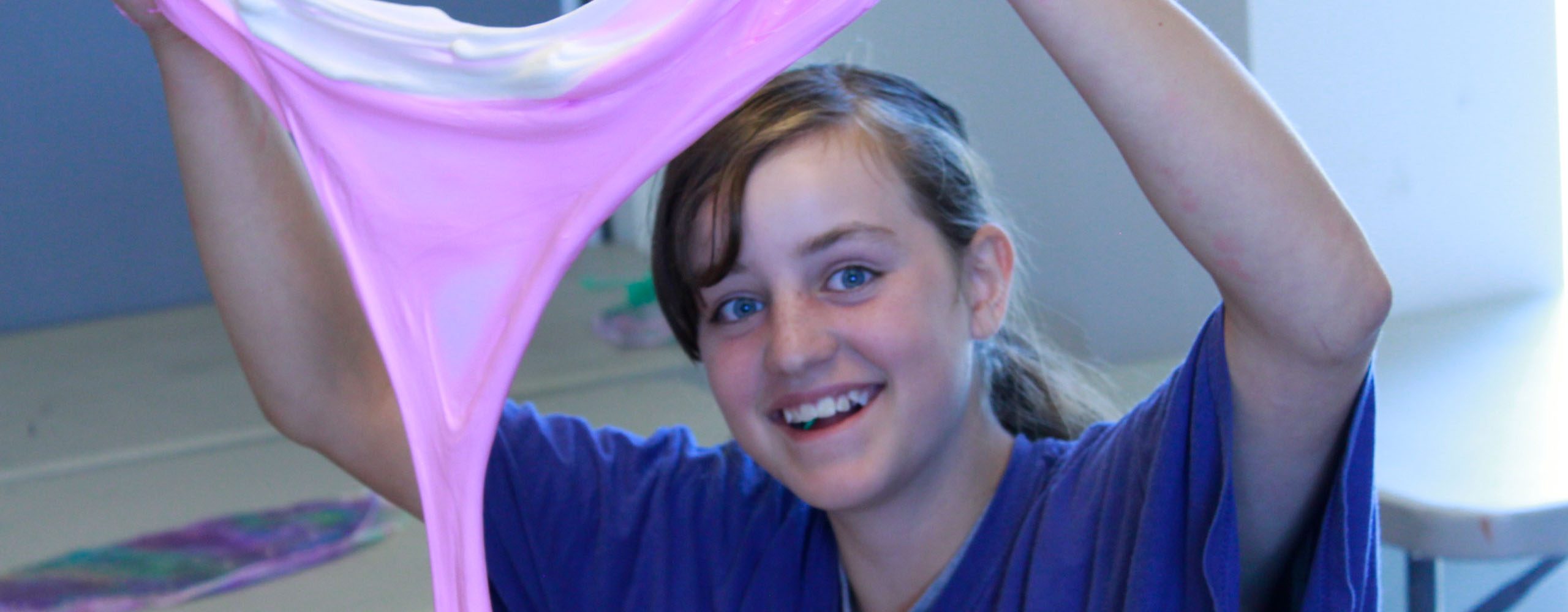 pre-teen girl showing off slime project in summer camp crazy messy art class