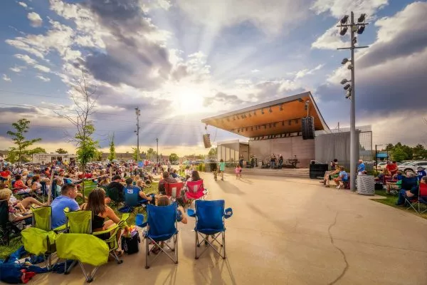 Crowd in chairs surrounding stage during performance at Discovery Park in Parker, CO.